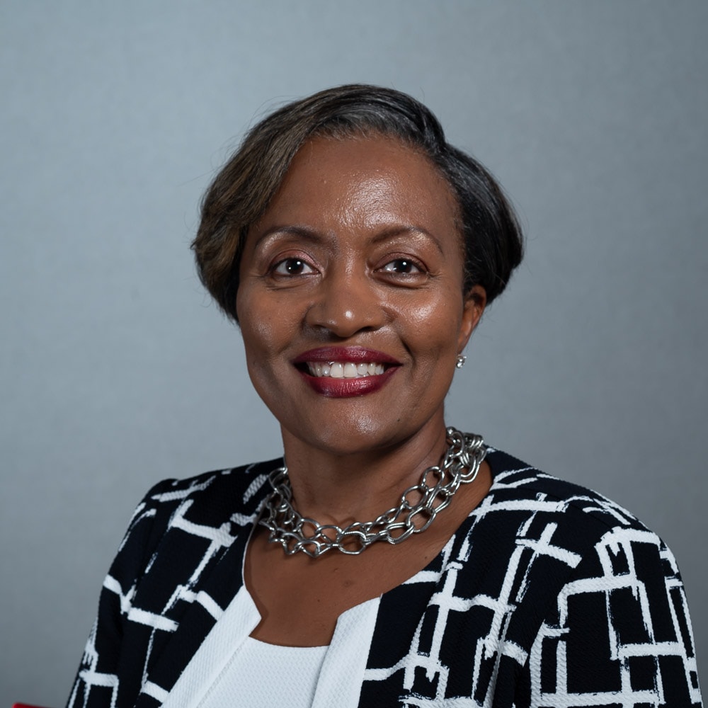 Professional headshot of woman in black and white blazer
