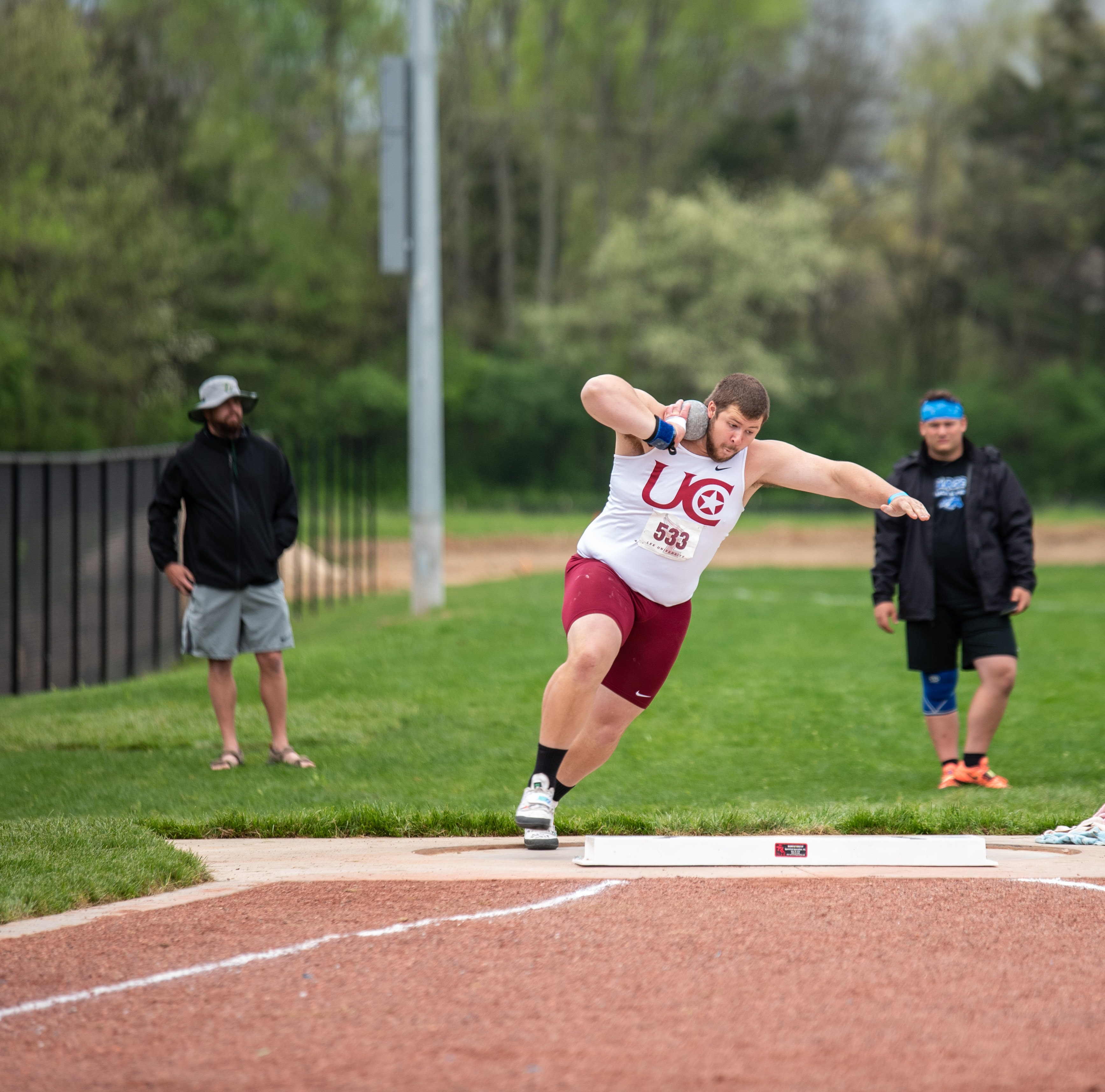 Shot put athlete winding up for the throw at UC track meet