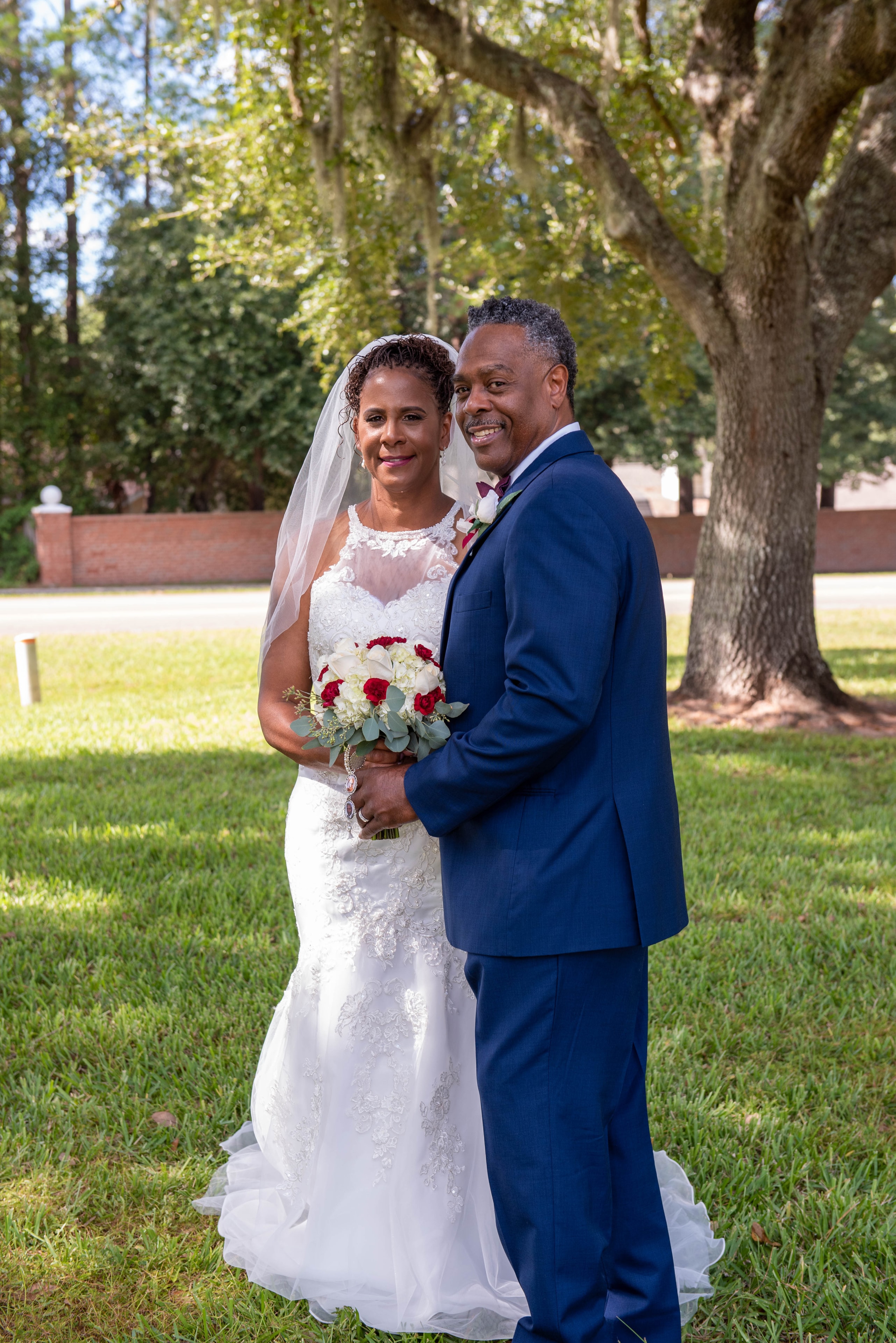 Bride and groom smiling together outdoors under Spanish moss